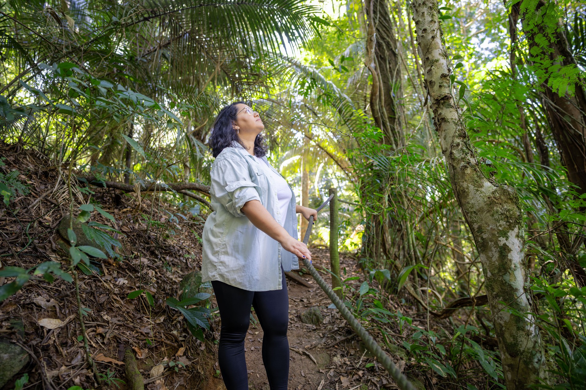Beautiful woman descending difficult trail in the Amazon rainforest.